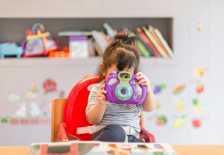 A toddler playing with a toy camera